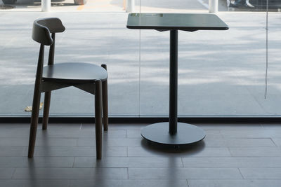 Empty chairs and table on tiled floor