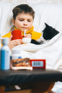 Boy with cat on bed