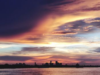 Scenic view of sea and buildings against sky during sunset