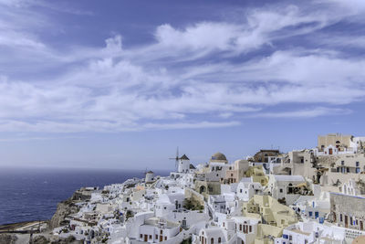 Buildings by sea against sky