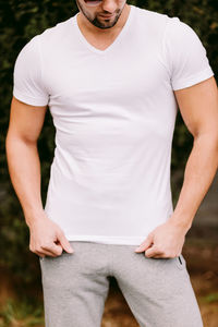 Midsection of man wearing t-shirt standing in park