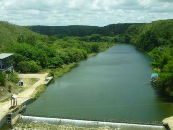 Scenic view of river amidst trees against sky