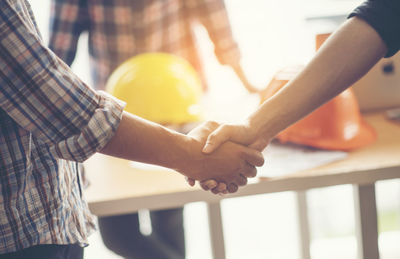 Midsection of couple holding hands