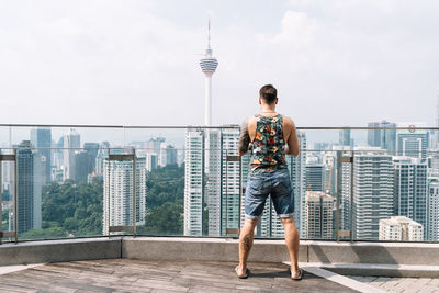 Full length of man standing by buildings against sky