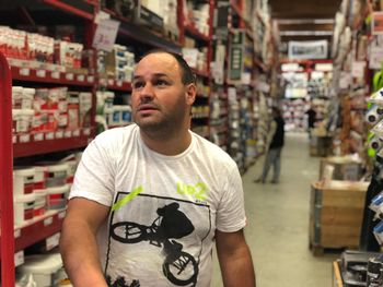 Man looking away while standing in supermarket