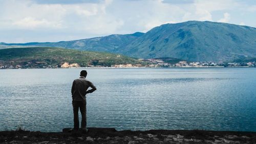 Rear view of man standing in front of mountains