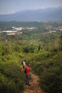 People standing on landscape against mountains