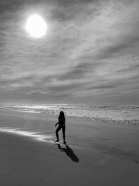 Full length of woman on beach against sky