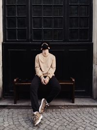 Full length of young man sitting on seat