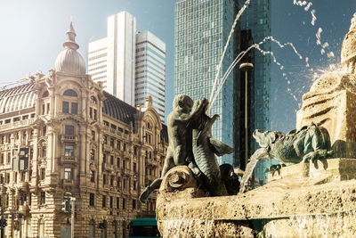 Low angle view of statue against buildings in city