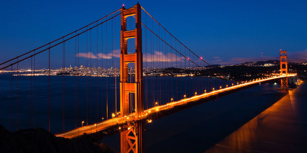 View of suspension bridge in city at night