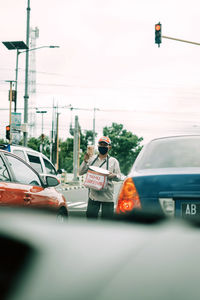 Man standing on road against sky in city