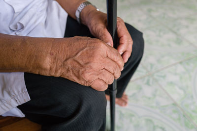 Hands of a senior man holding a walking stick