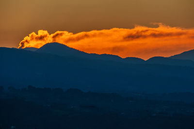 Scenic view of silhouette mountains during sunset