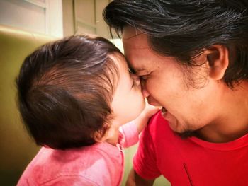 Close-up of son biting father nose