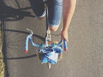 Midsection of person riding bicycle on street