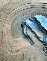 High angle view of rock on wet sand at beach
