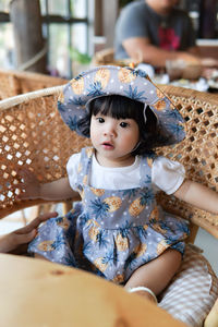 Portrait of cute baby girl sitting at restaurant