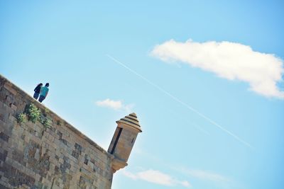 Tilt shot of couple at old cathedral of lleida against sky