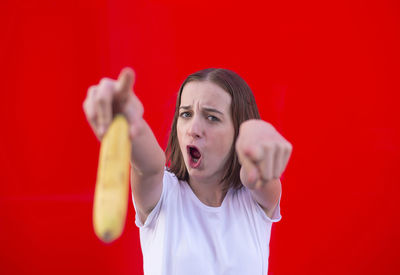 Portrait of mid adult man standing against red background