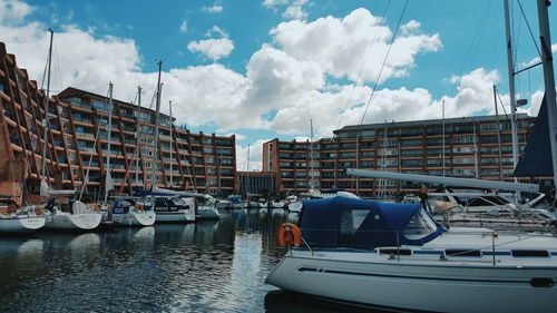 Boats moored in city against sky