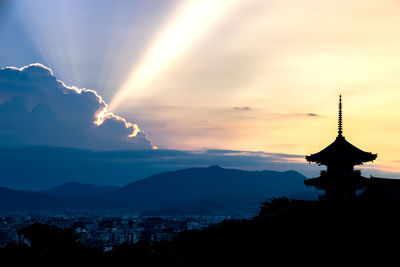 Silhouette built structures against scenic sky