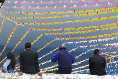 Rear view of people at temple against sky