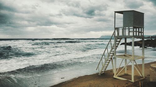 Lifeguard hut on beach against sky