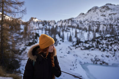 Rear view of woman standing on snow covered landscape