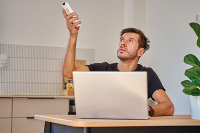 Young man using digital tablet while sitting on table