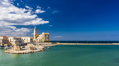 View of buildings in sea against cloudy sky