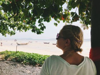 Portrait of woman looking away against plants