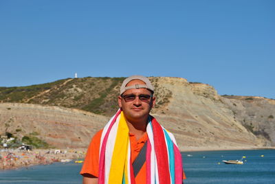 Portrait of man standing by sea against clear sky