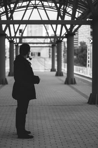 Man smoking pipe while standing on footpath