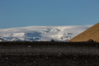 Scenic view of snowcapped mountains against clear blue sky