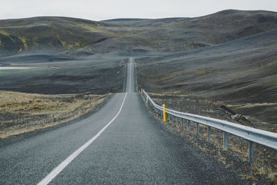 Empty road leading towards mountains