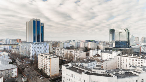 Aerial view of buildings in city against sky