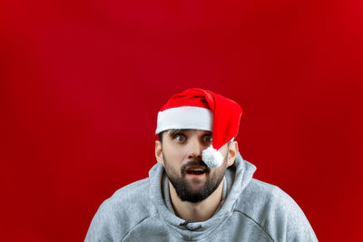 Portrait of man wearing hat against red background