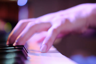 Close-up of hand touching piano key, instrument music
