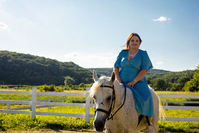 Young woman riding horse on field