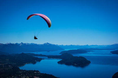 People paragliding over mountains against sky