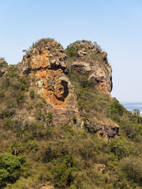 Rock formation on cliff against clear sky