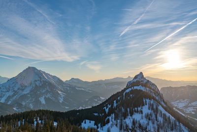 Scenic view of snowcapped mountains against sky during sunset