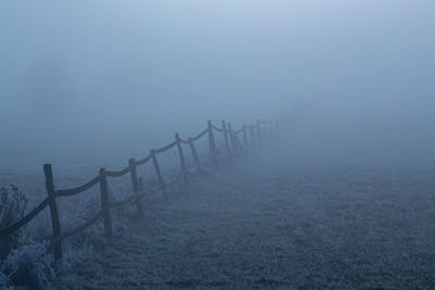 Fence on land against sky