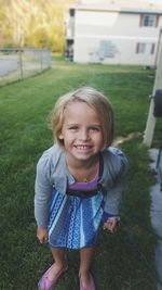 Portrait of smiling girl standing at yard