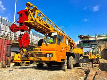 Earth mover at construction site against sky