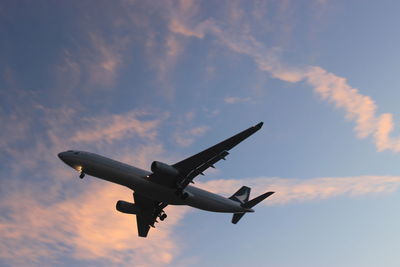 Low angle view of airplane flying against sky