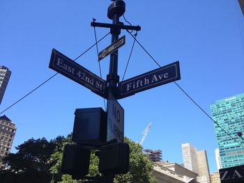 Low angle view of road sign against clear sky