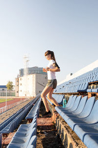 Woman standing on walkway against clear sky