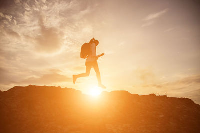 Low angle view of man standing on mountain against sky